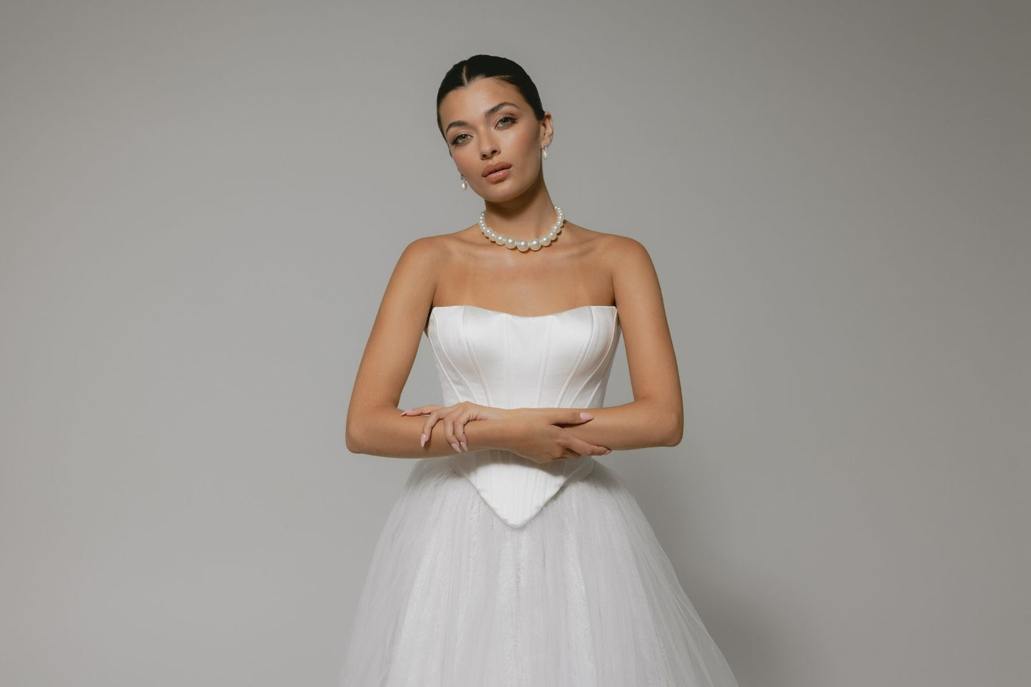 two-piece wedding gown, boned corset top with sharp V basque waist, paired with a pleated voluminous tulle skirt