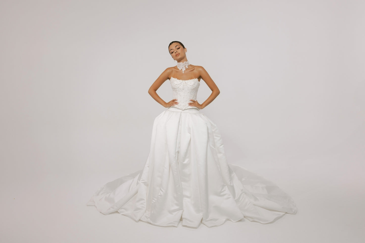 two-piece wedding gown, elaborate corset with hip panels, draped in pearls. paired with a high fashion pleated mikado skirt