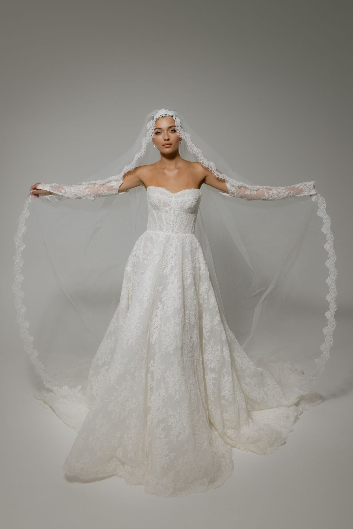 Lace A-line wedding gown with off the shoulder sleeves, dramatic chapel train