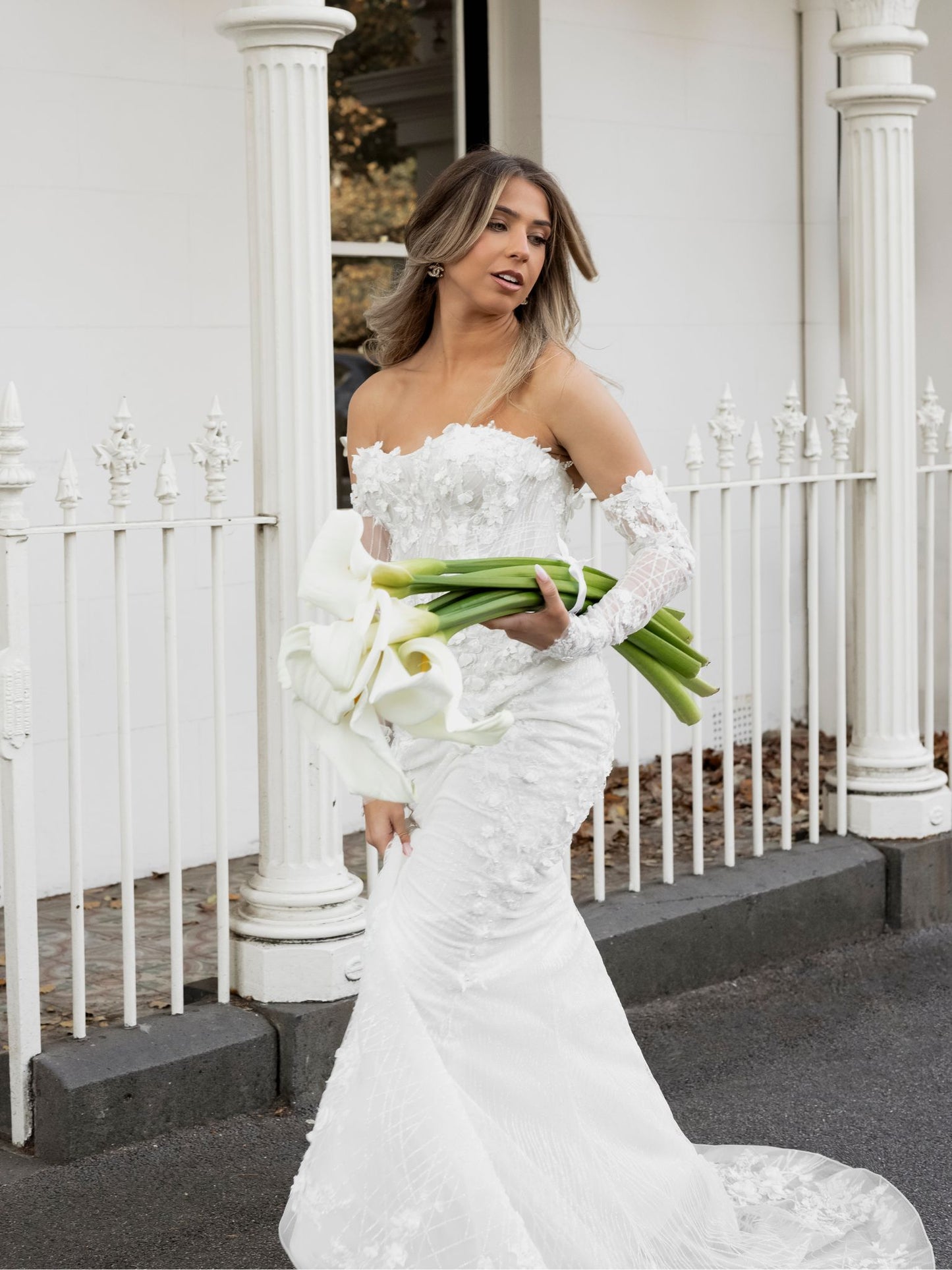 FION Bridal Gown by Windsor Collection Jessica Couture. Fit-n-Flare gown with strapless neckline, fitted gloves, and beaded floral lace.