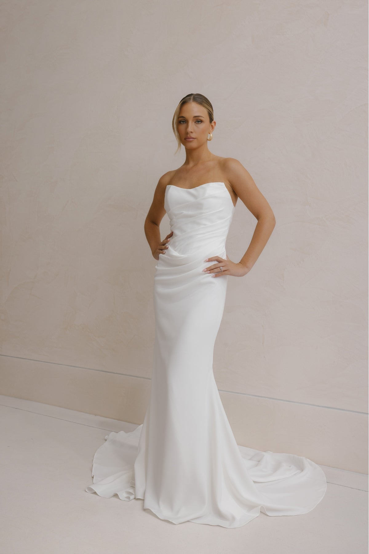 fitted crepe Bridal gown, strapless neckline, drapings around bust and hips. Paired with a scarf