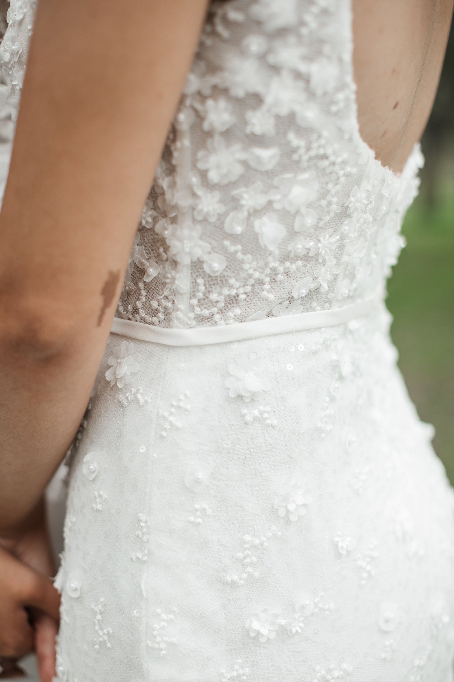 Back view of Kristy. Ivory fit-n-flare wedding gown with delicate 3D florals and beads. Sheer boned corset with plunging backline imitating the square neckline.
