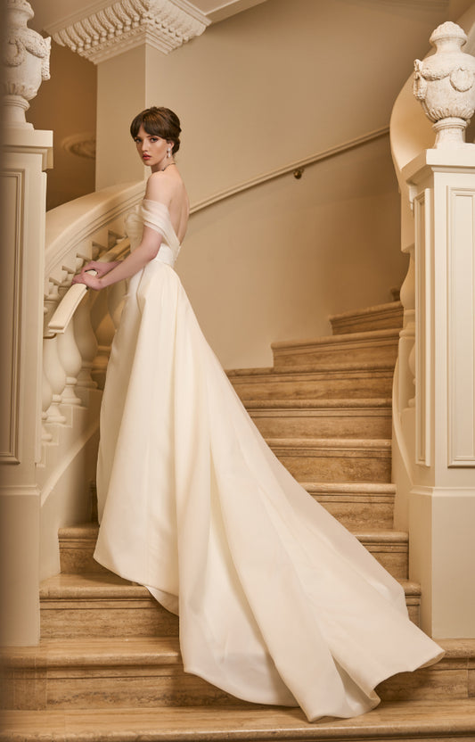 Side view of Tamsin gown with detachable Tamsin overskirt made from ivory organza. Overskirt is structured and voluminous