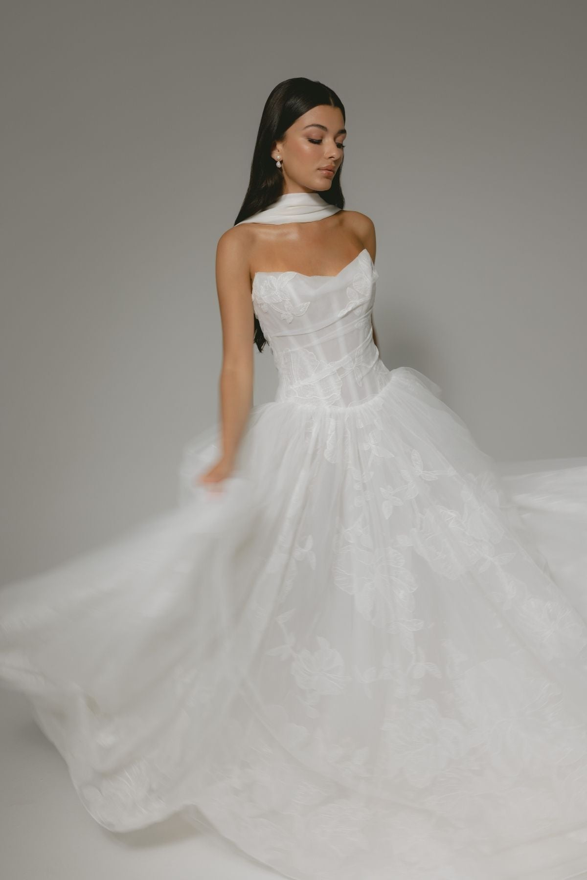 A-line wedding gown, subtle floral pattern, strapless corset boning bodice. paired with a chiffon scarf