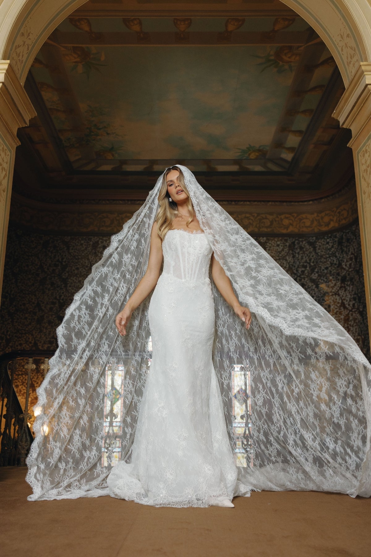 Fitted lace bridal gown featuring a cateye neckline, scalloped lace train.