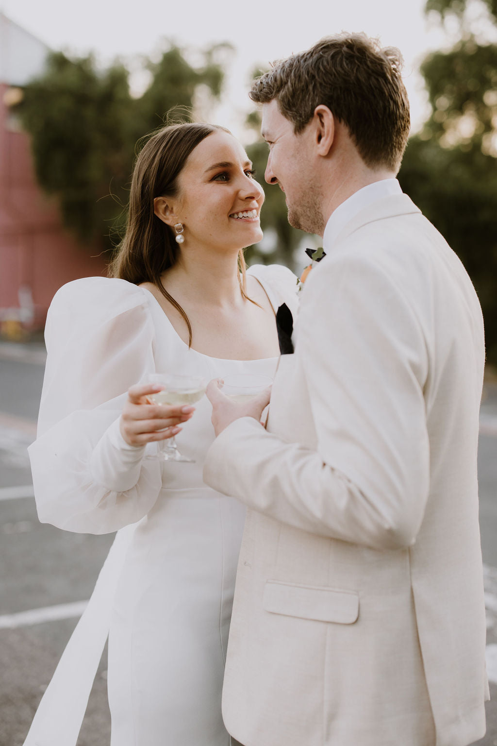 Real bride wearing ivory soraya gown looking at her husband.