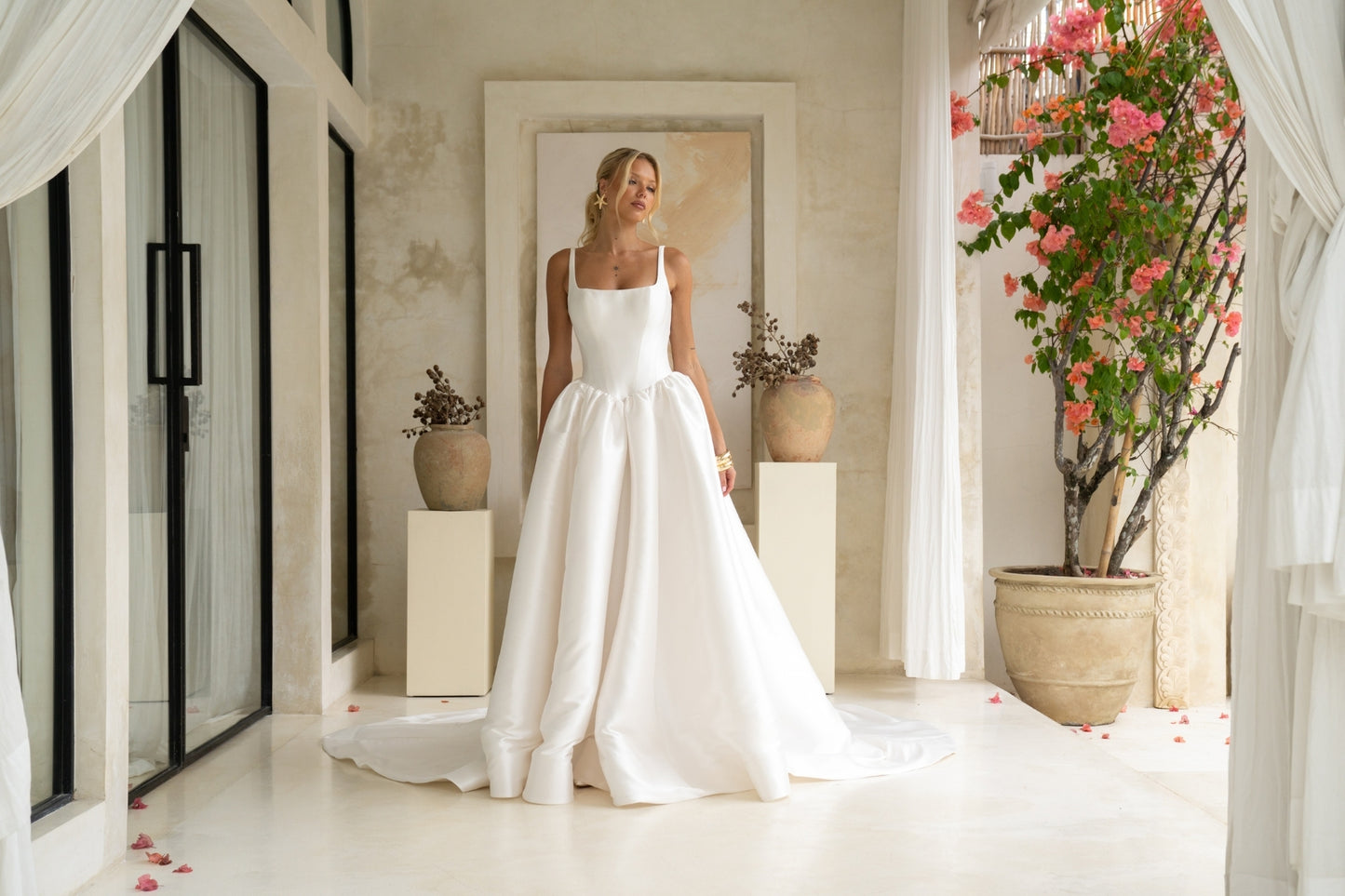 Dramatic A-line wedding gown featuring a squared neckline with straps. subtle basque waist with ruching all around waistline. chapel train.