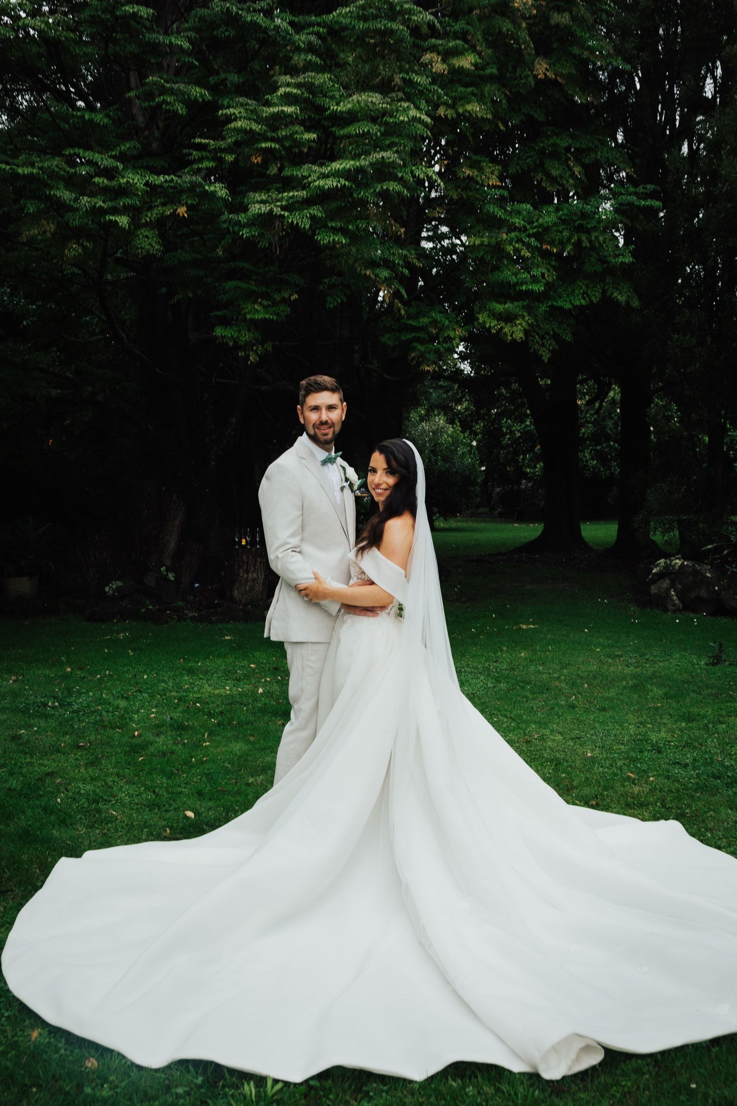 Jessica Couture bride rebecca christina in her namesake dress with husband. Image features dramatic train of gown.