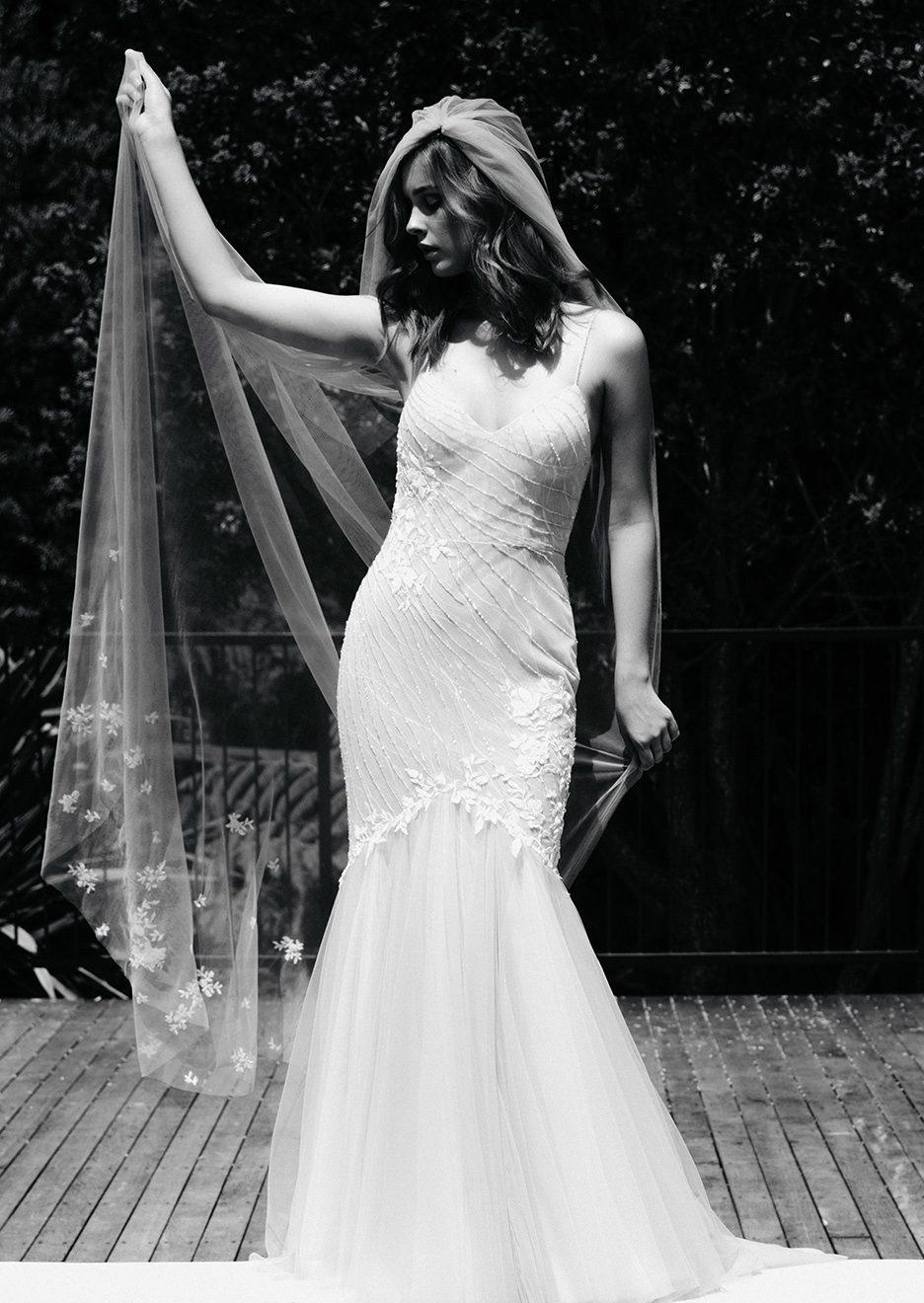 Bride holds Nebraska veil behind her. Veil is soft tulle stitched with 3D flowers