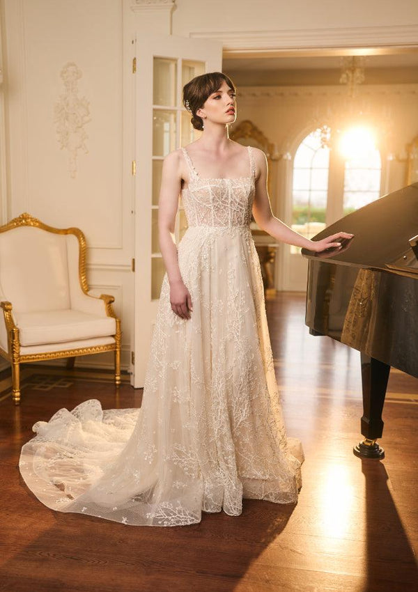 Ivory Bridal gown with sheer lace embroidered with beaded branches. Square neckline with thin straps and a-line skirt.