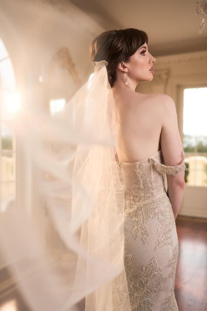 Back view of Taya dress hugging the figure with gold lace applique. Most of dress hidden by tulle veil.