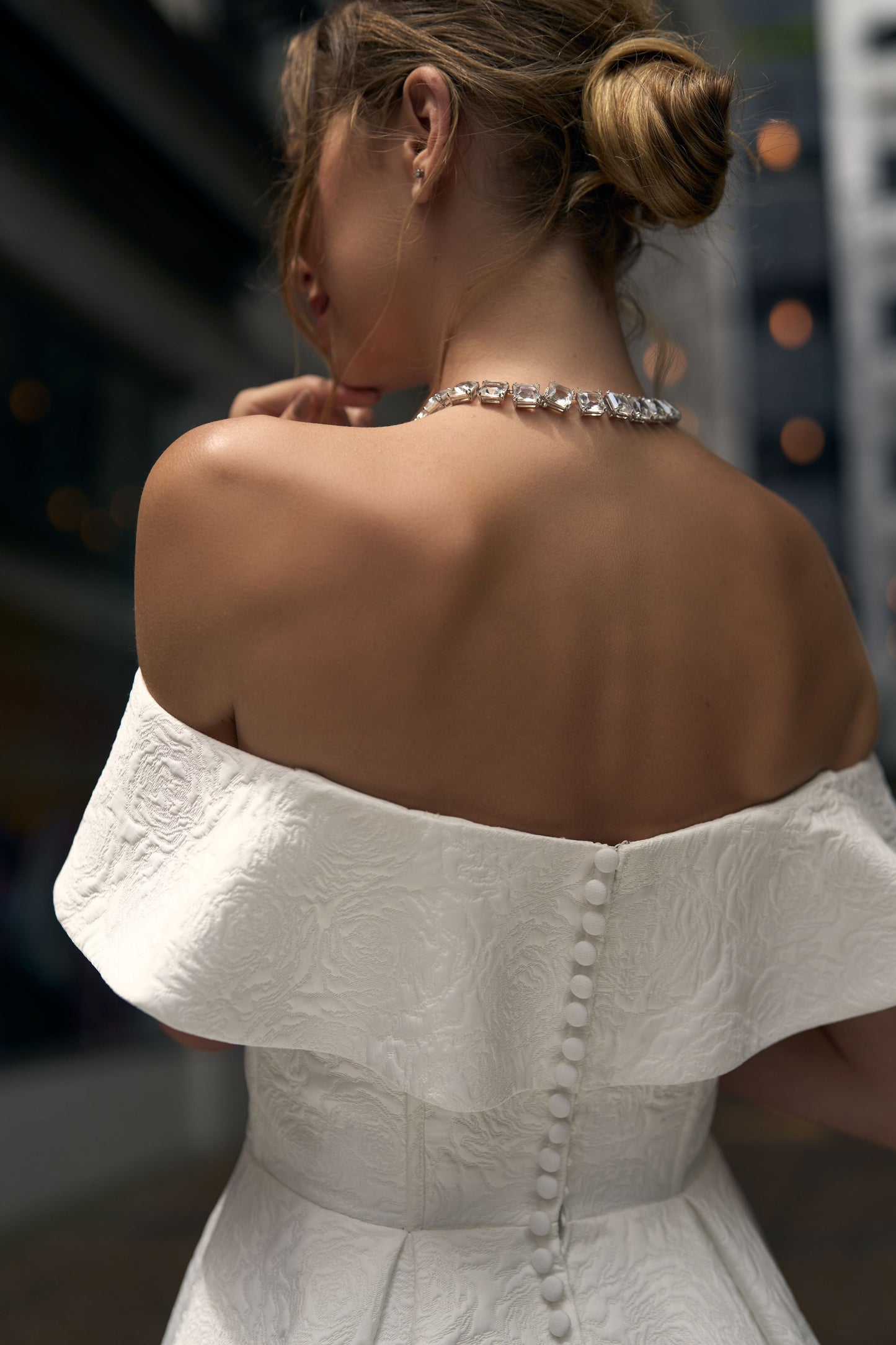 Rose dress, A-line skirt in jacquard ivory fabric. Off-the-shoulder cross-over sweetheart neckline with waved off-the-shoulder straps. Covered buttons run down back zip.