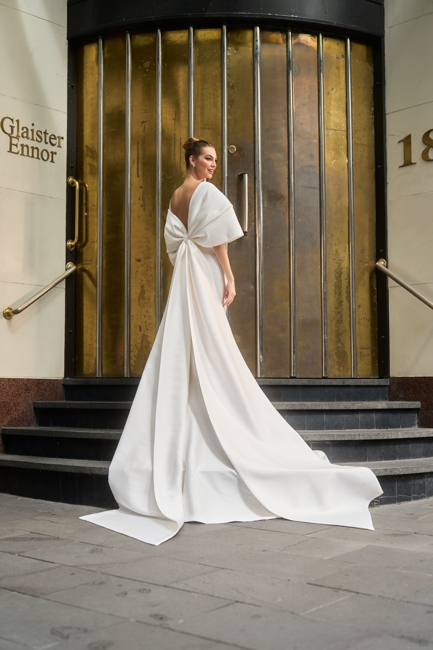 Back view of oversized bow that wraps over arms and becomes part of train.