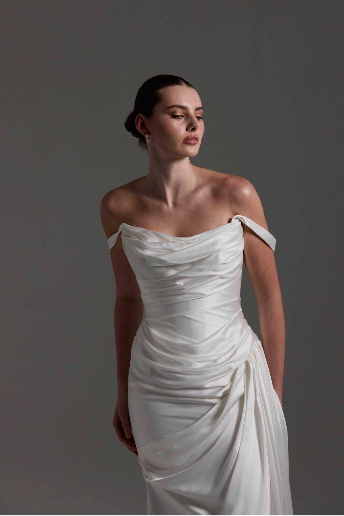 fitted satin wedding dress with pleats across bust and hips. Featuring off the shoulder straps. 
