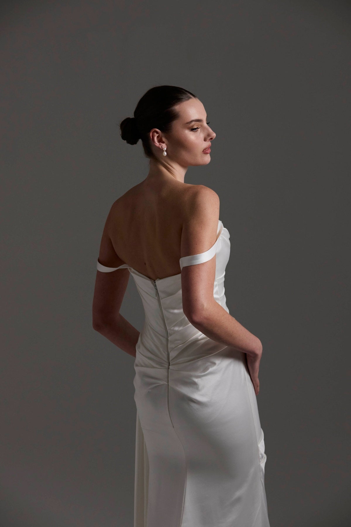 fitted satin wedding dress with pleats across bust and hips. Featuring off the shoulder straps. 