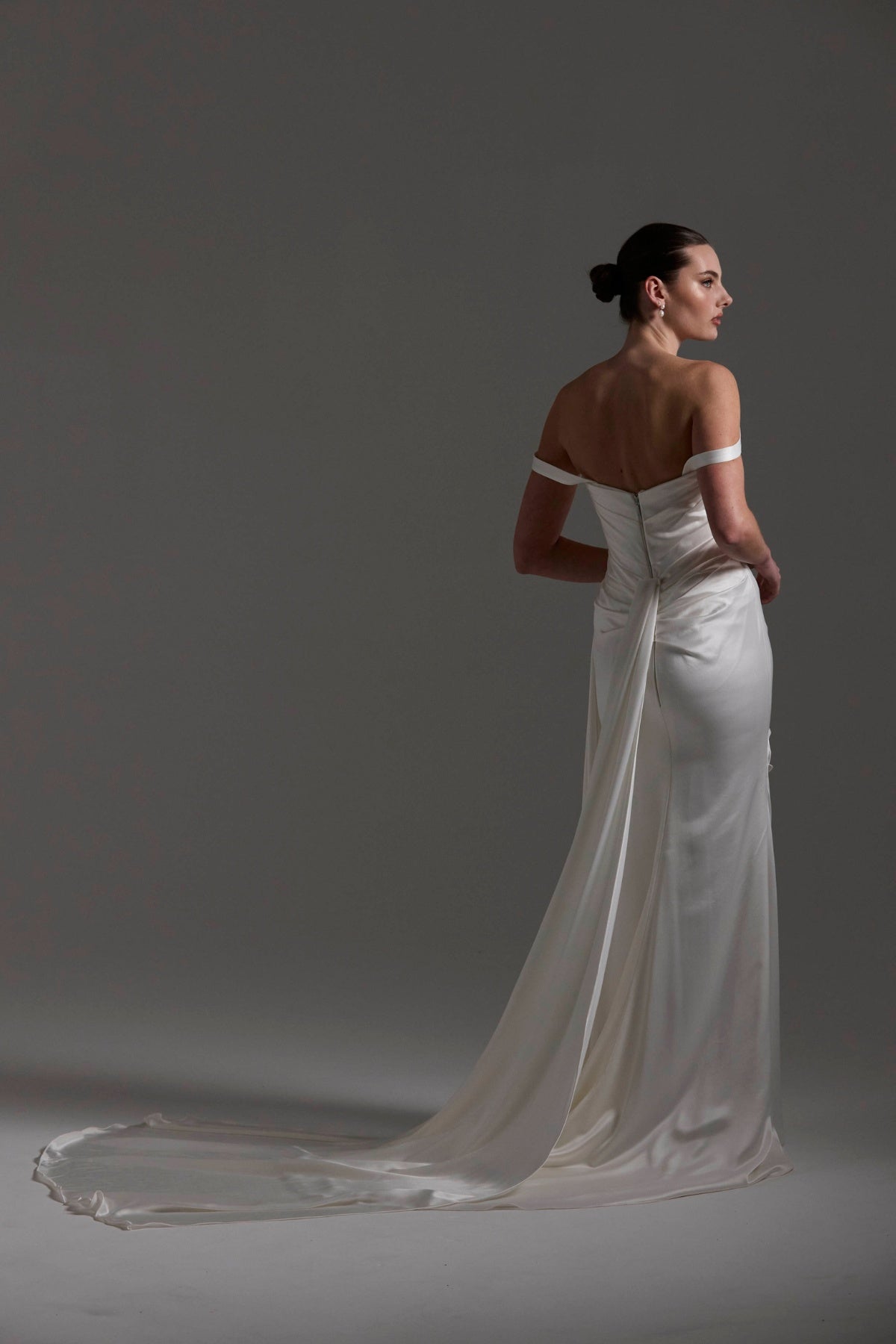 fitted satin wedding dress with pleats across bust and hips. Featuring off the shoulder straps. 