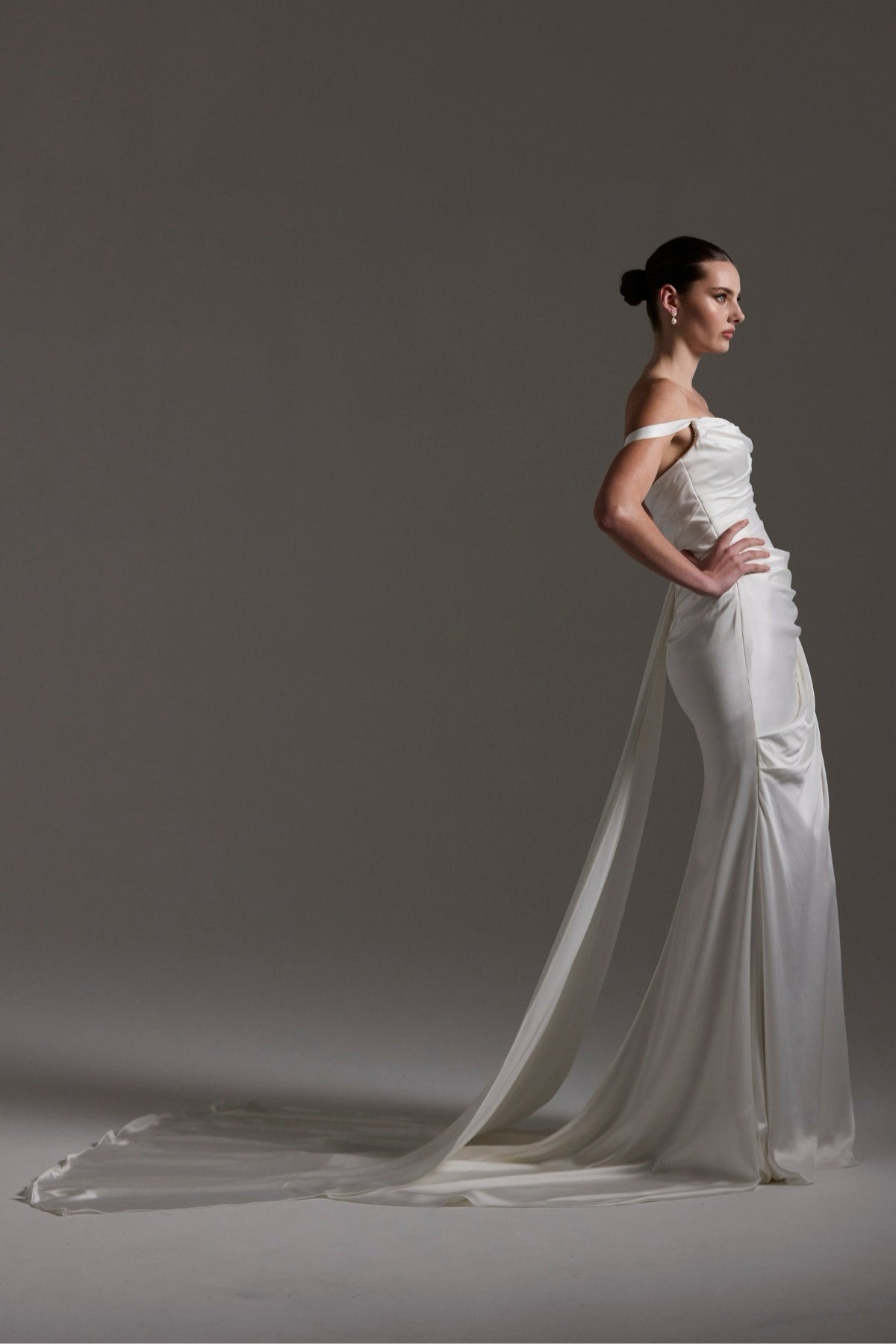 fitted satin wedding dress with pleats across bust and hips. Featuring off the shoulder straps. 