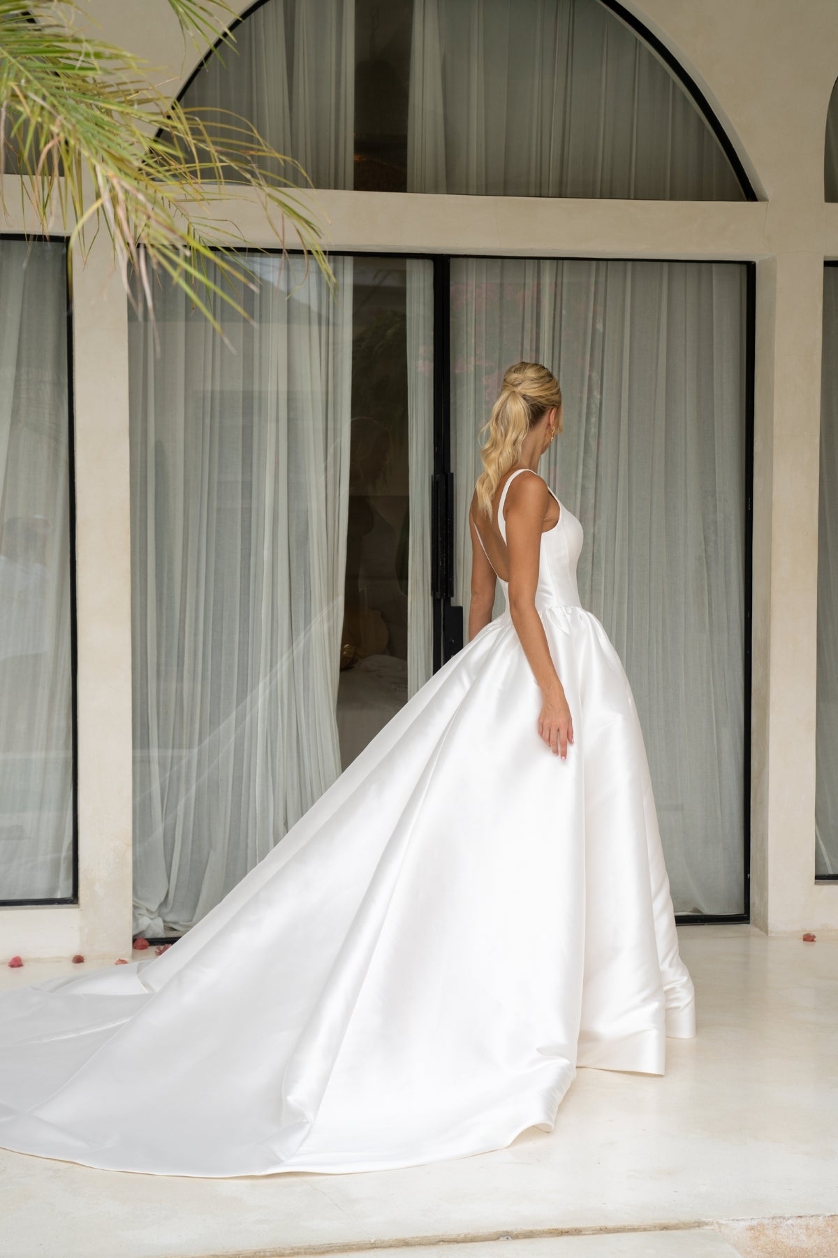 Dramatic A-line wedding gown featuring a squared neckline with straps. subtle basque waist with ruching all around waistline. chapel train. 