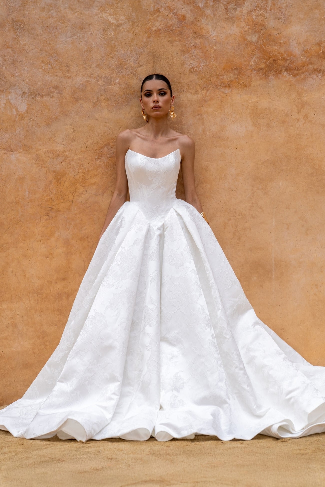 dramatic A-line wedding dress in floral jacquard fabric, featuring a steep basque waist and cat-eye neckline 