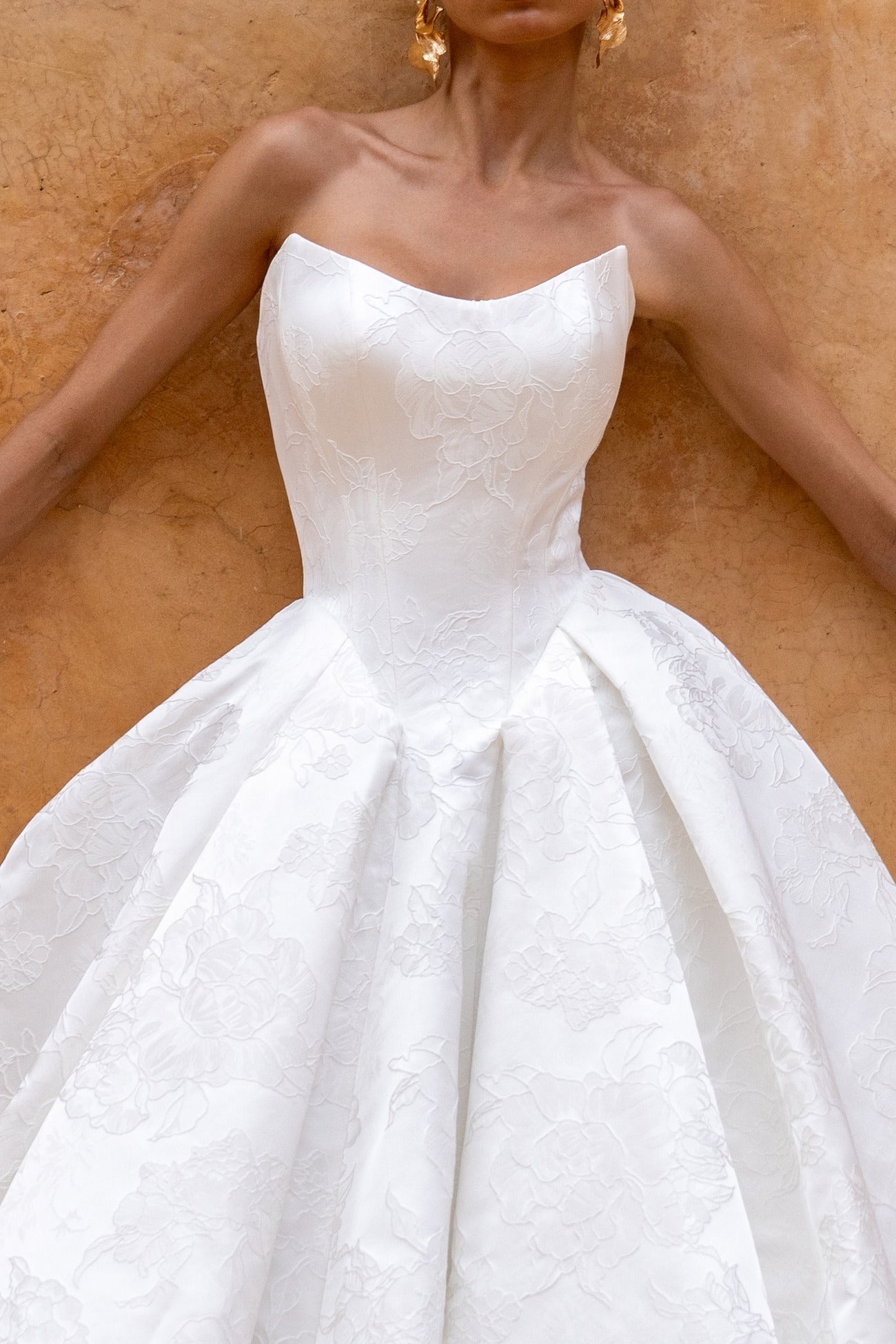 dramatic A-line wedding dress in floral jacquard fabric, featuring a steep basque waist and cat-eye neckline 