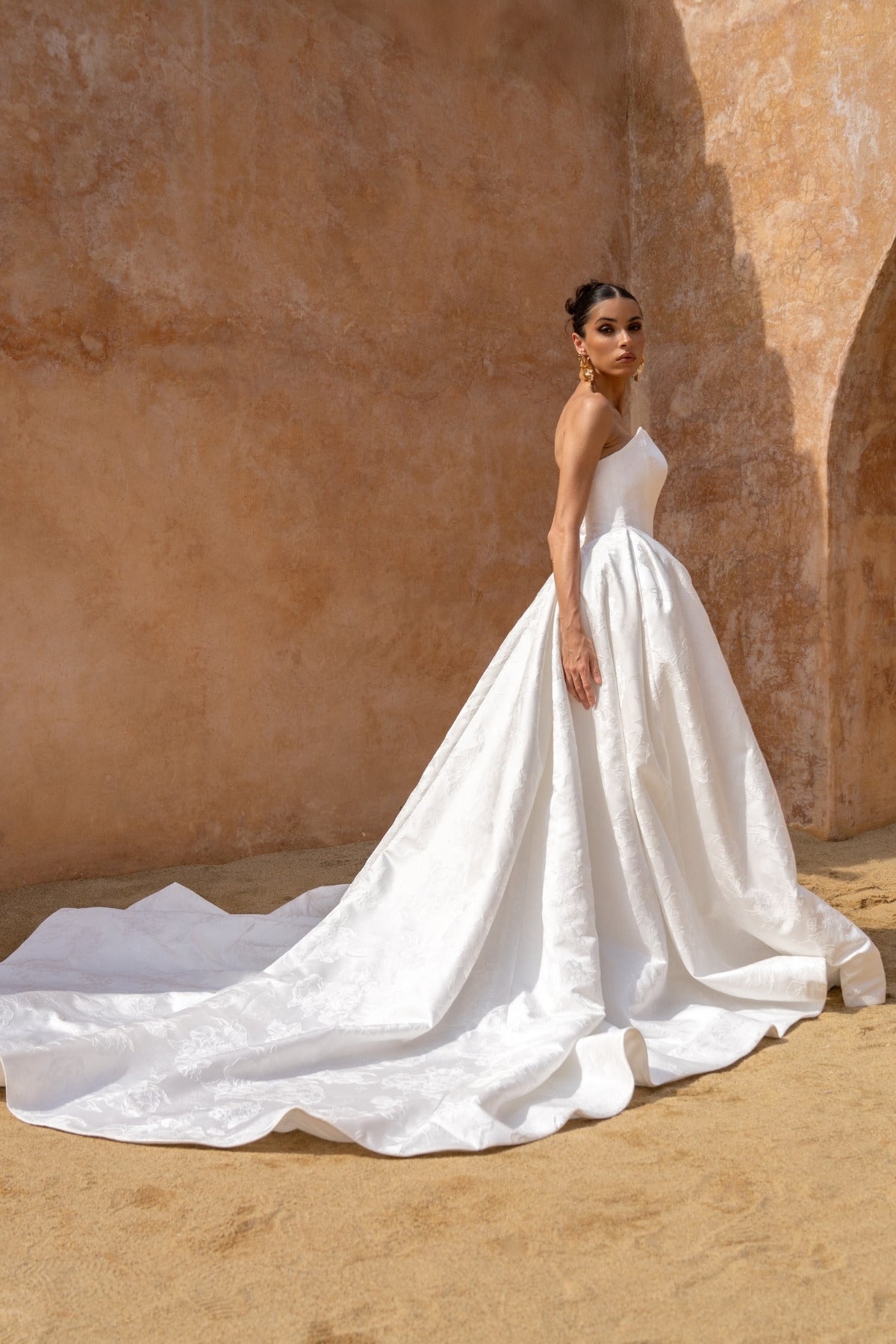 dramatic A-line wedding dress in floral jacquard fabric, featuring a steep basque waist and cat-eye neckline 