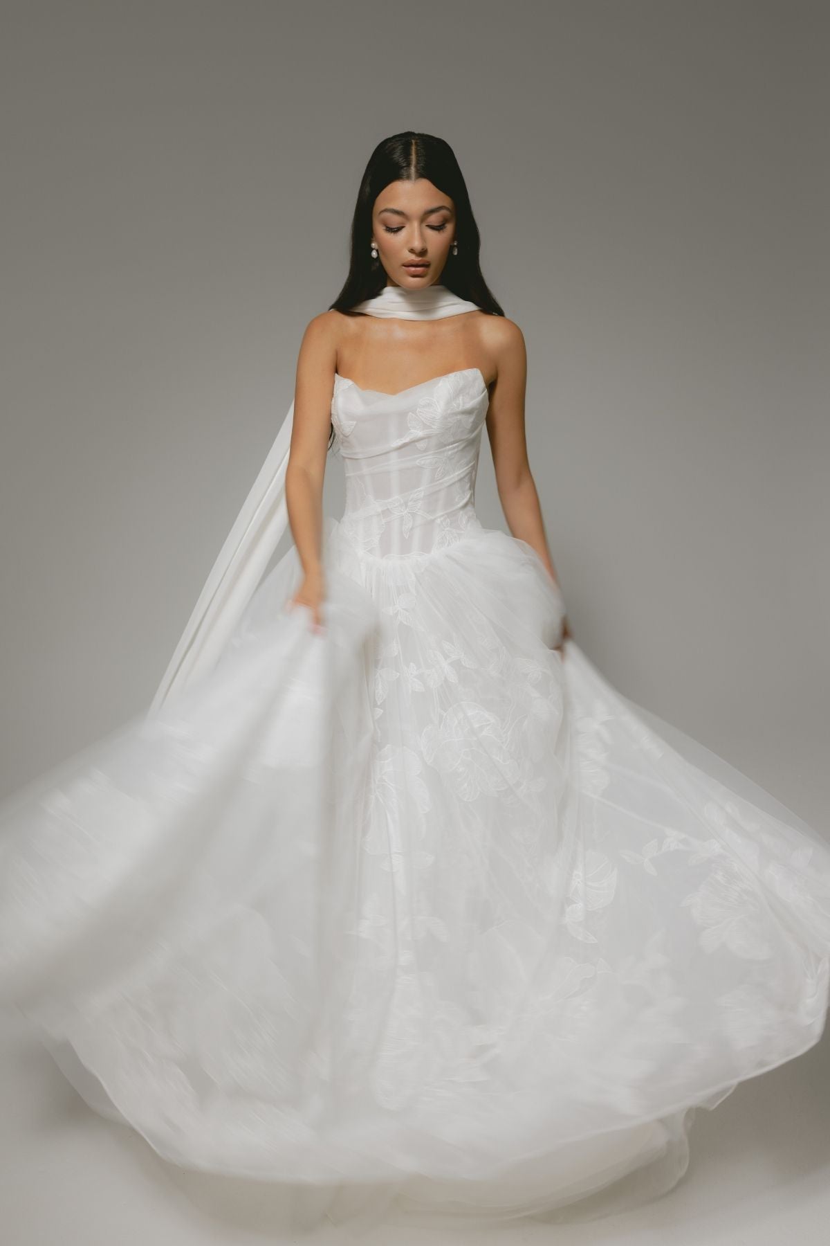 A-line wedding gown, subtle floral pattern, strapless corset boning bodice. paired with a chiffon scarf 