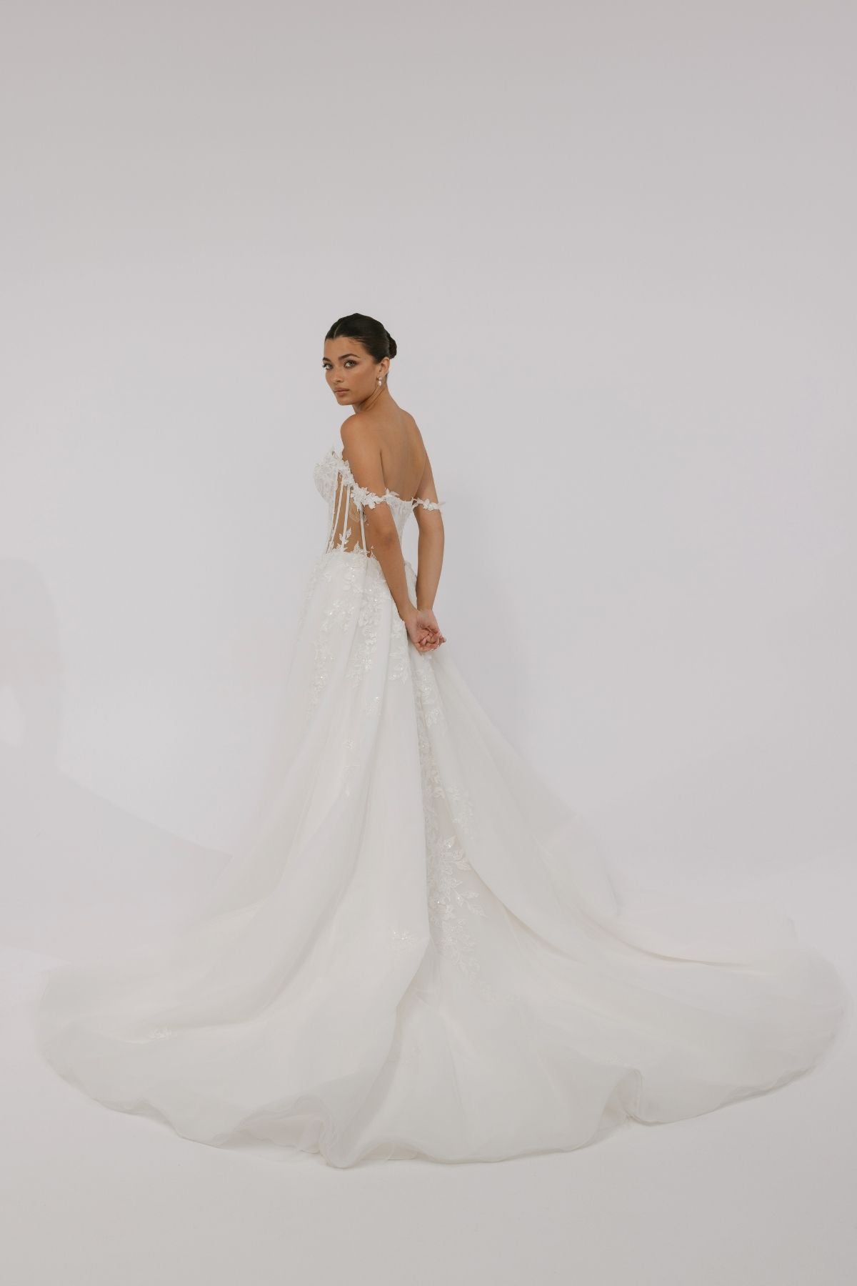 wedding dress featuring off the shoulder straps, sweetheart neckline, sheer boning on the sides, and floral lace A-line skirt 