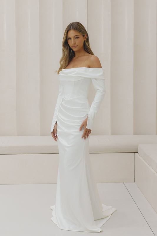 Satin fitted gown with off the shoulder neckline and long sleeves. 