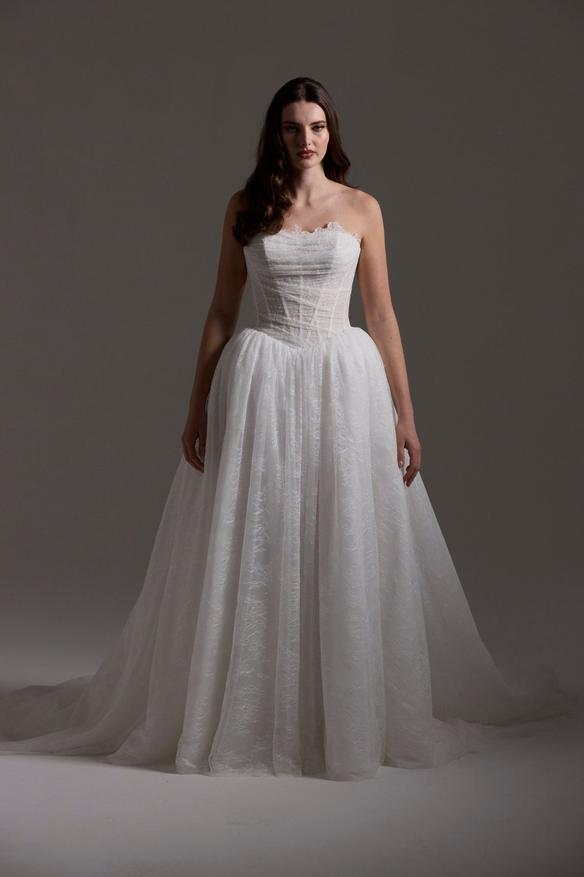 Lace wedding gown with A line skirt, featuring basque waist, strapless bodice and exposed corset boning 