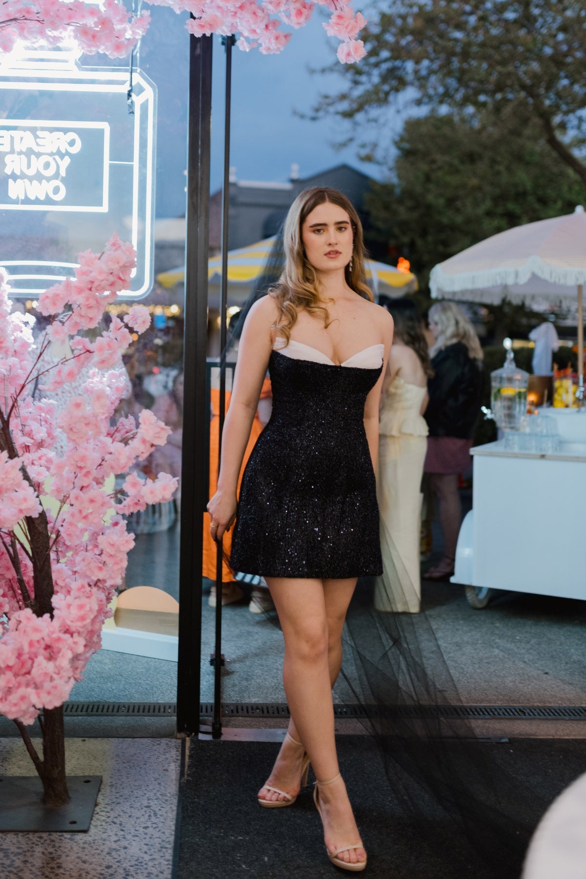 Fitted, sparkly black mini dress with ivory cups peeking through the bodice 