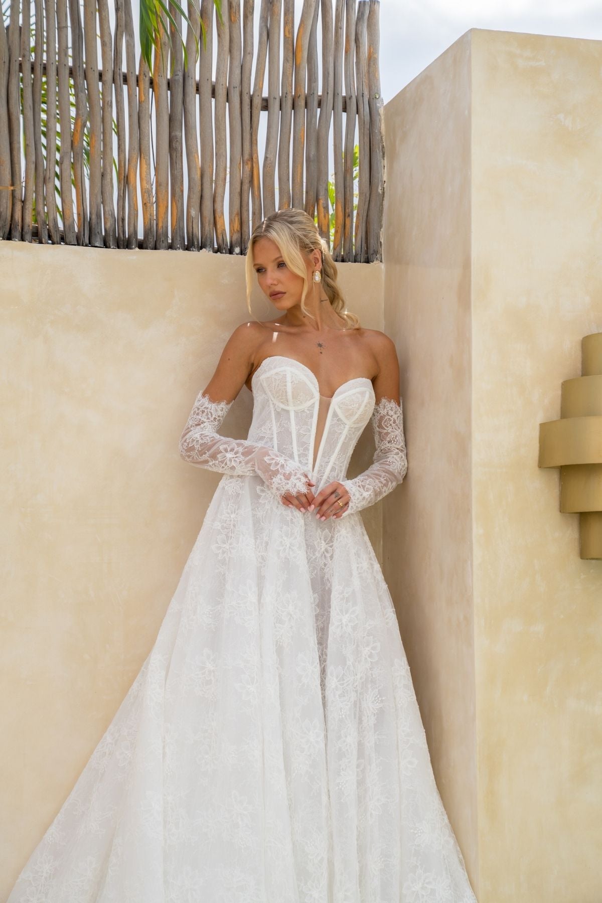 Lace A-line wedding gown with deep v plunge and sweetheart neckline, basque wasitline and fitted lace sleeves. 