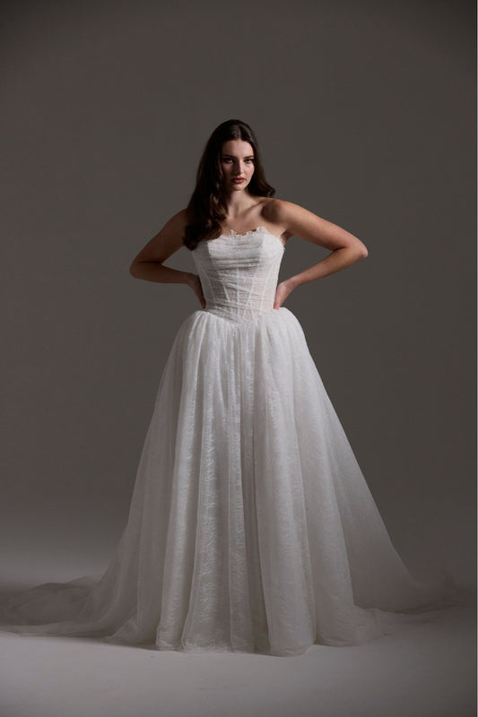 Lace wedding gown with A line skirt, featuring basque waist, strapless bodice and exposed corset boning 