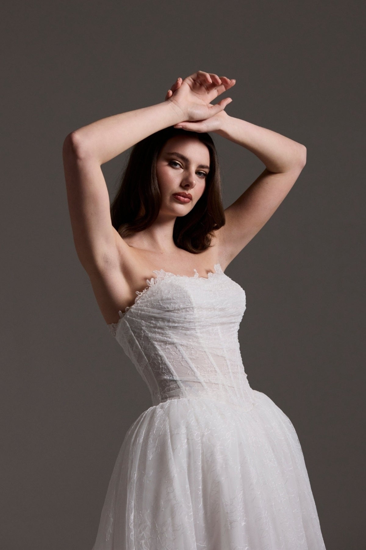Lace wedding gown with A line skirt, featuring basque waist, strapless bodice and exposed corset boning 