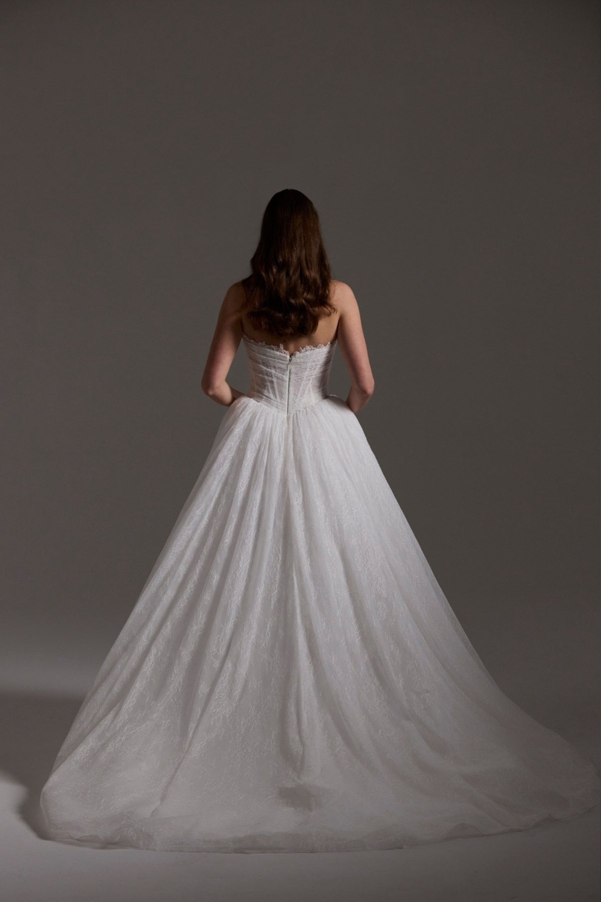 Lace wedding gown with A line skirt, featuring basque waist, strapless bodice and exposed corset boning 