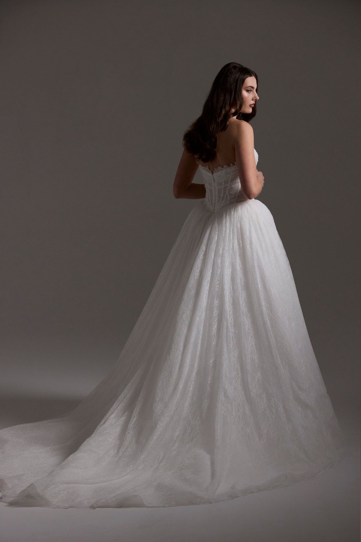 Lace wedding gown with A line skirt, featuring basque waist, strapless bodice and exposed corset boning 