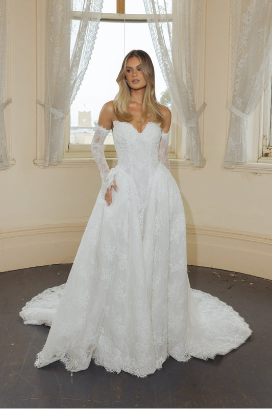 A-line wedding dress in lace, featuring a sweetheart neckline and steep basque waist, full of volume and drama. fitted lace sleeves included 
