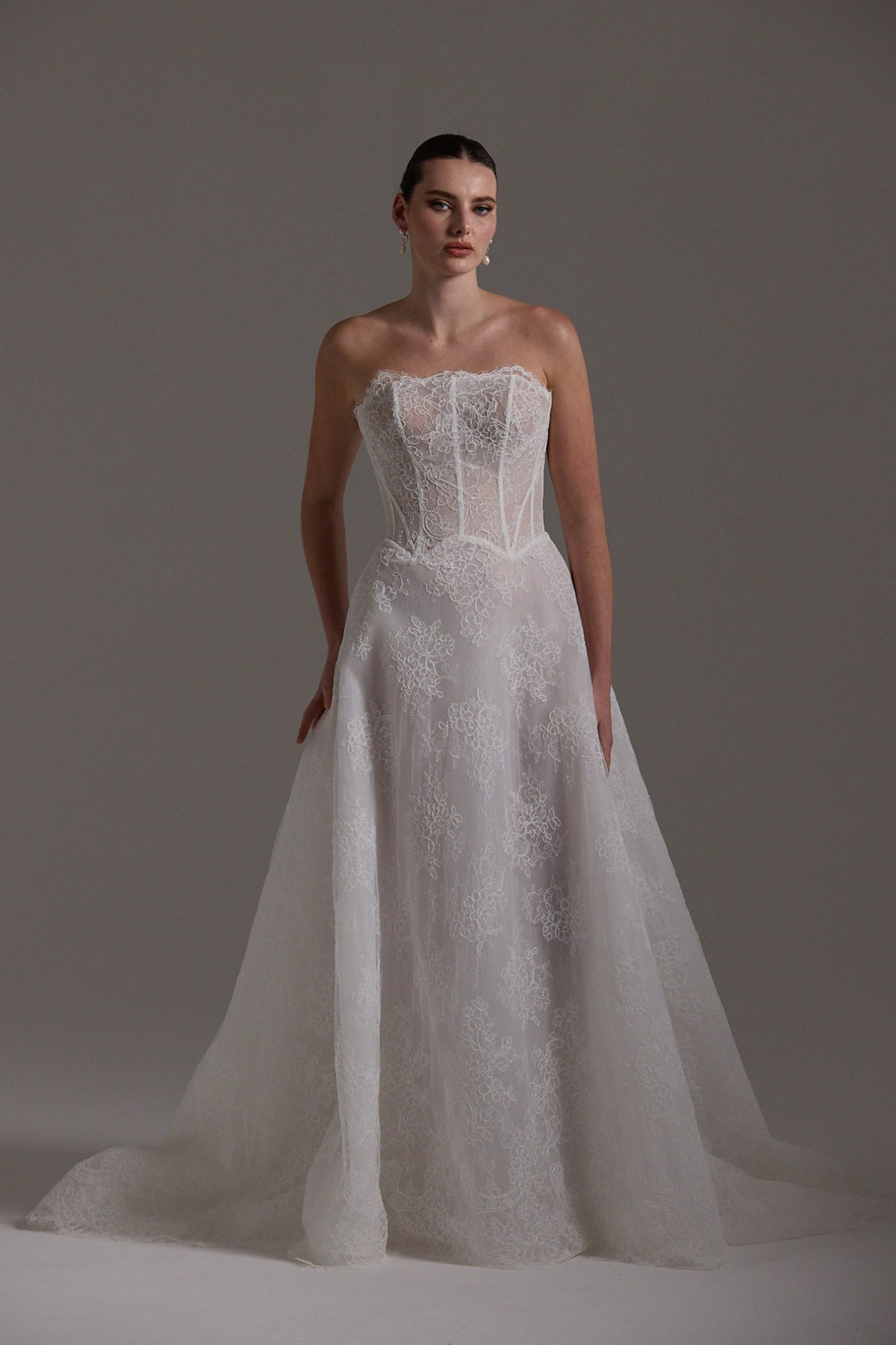 lace A-line wedding dress featuring a strapless neckline, exposed corset boning and unique waistline