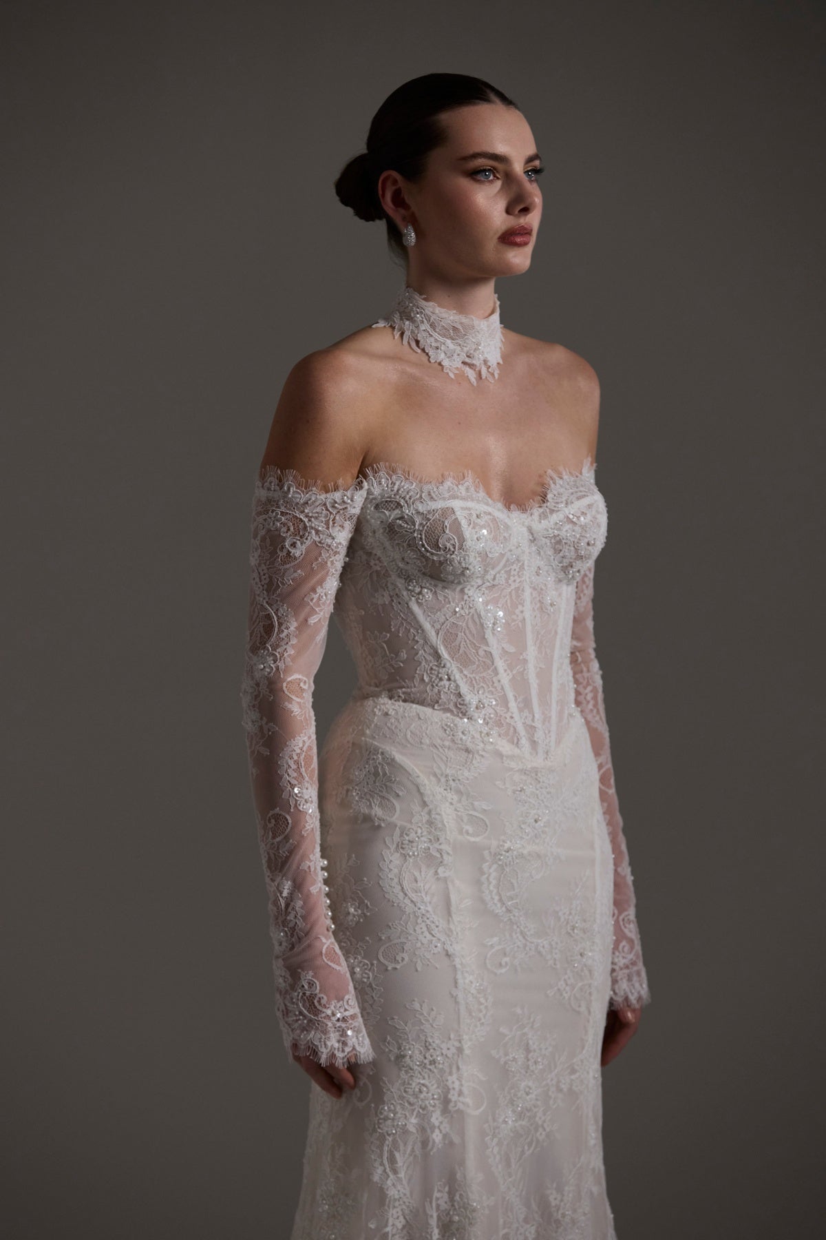 Fitted wedding gown featuring off-the-shoulder sleeves and neckline, vintage chantilly lace, basque waist, and lace choker. 