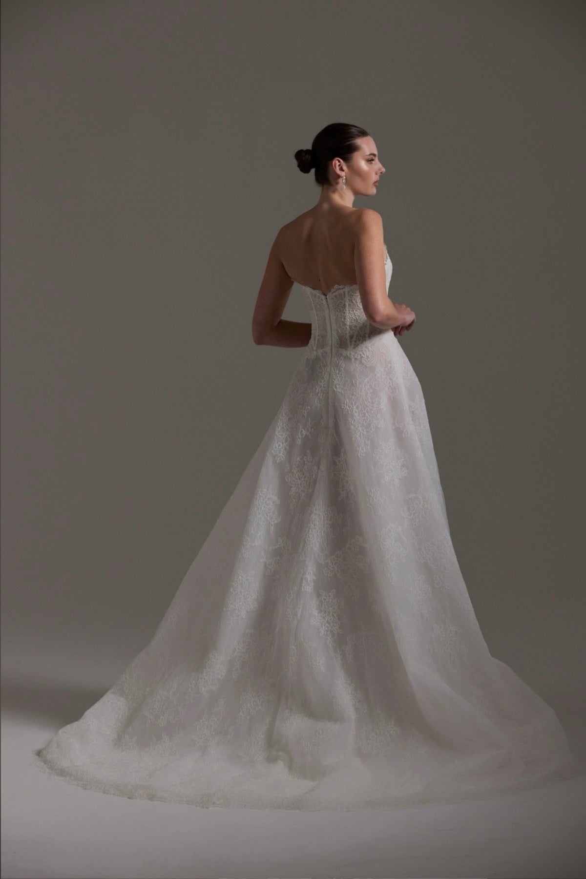 lace A-line wedding dress featuring a strapless neckline, exposed corset boning and unique waistline
