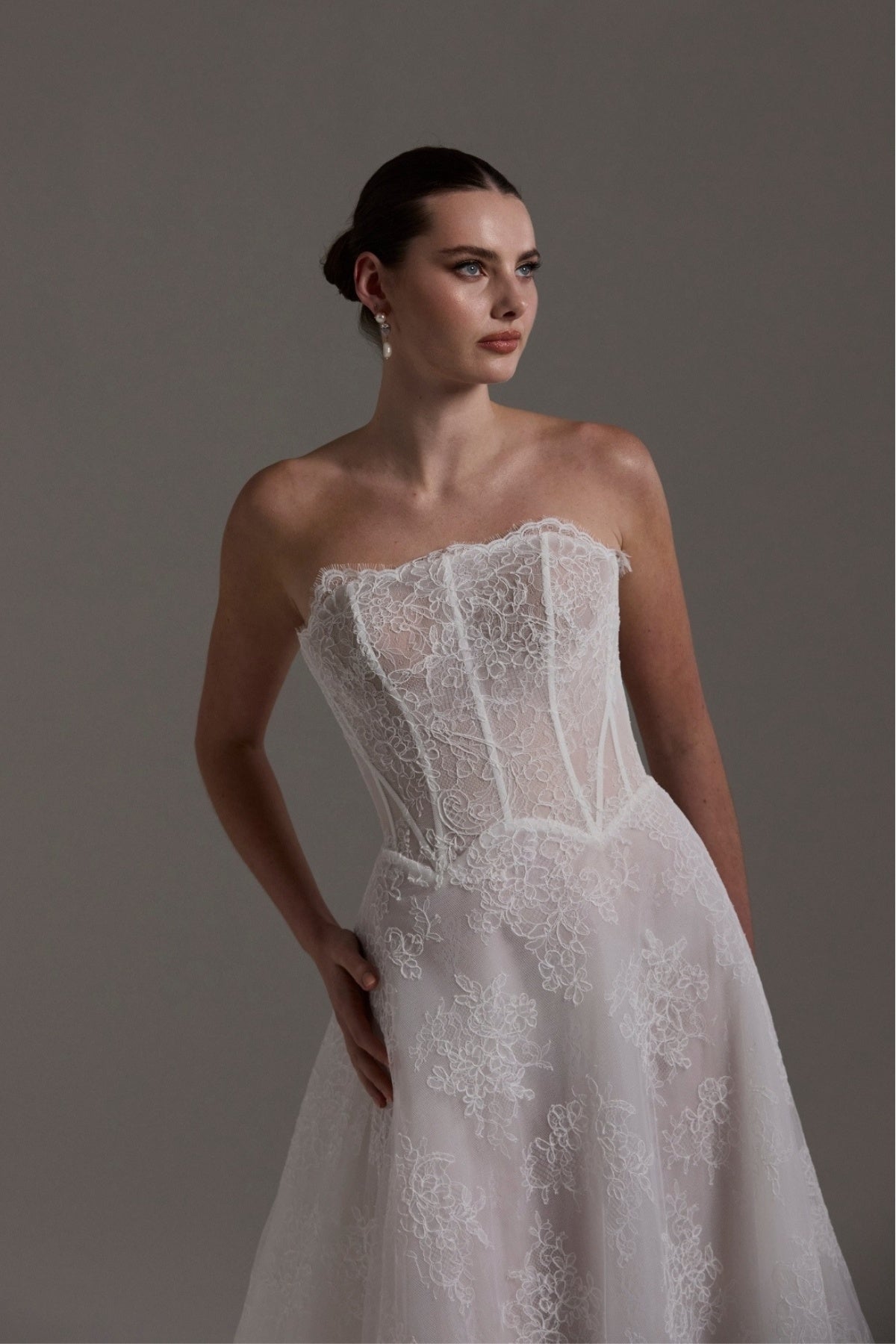 lace A-line wedding dress featuring a strapless neckline, exposed corset boning and unique waistline