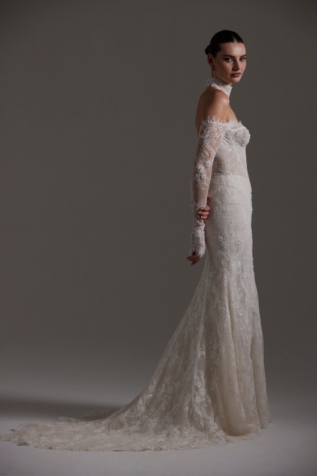 Fitted wedding gown featuring off-the-shoulder sleeves and neckline, vintage chantilly lace, basque waist, and lace choker. 