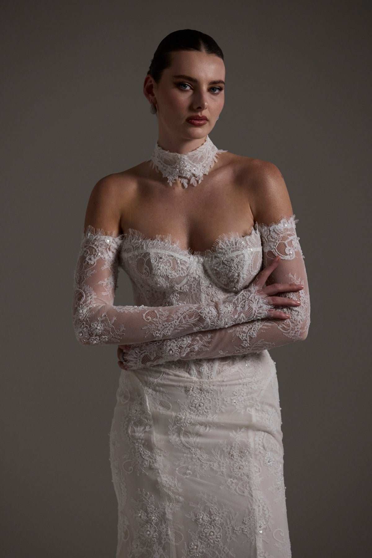 Fitted wedding gown featuring off-the-shoulder sleeves and neckline, vintage chantilly lace, basque waist, and lace choker. 