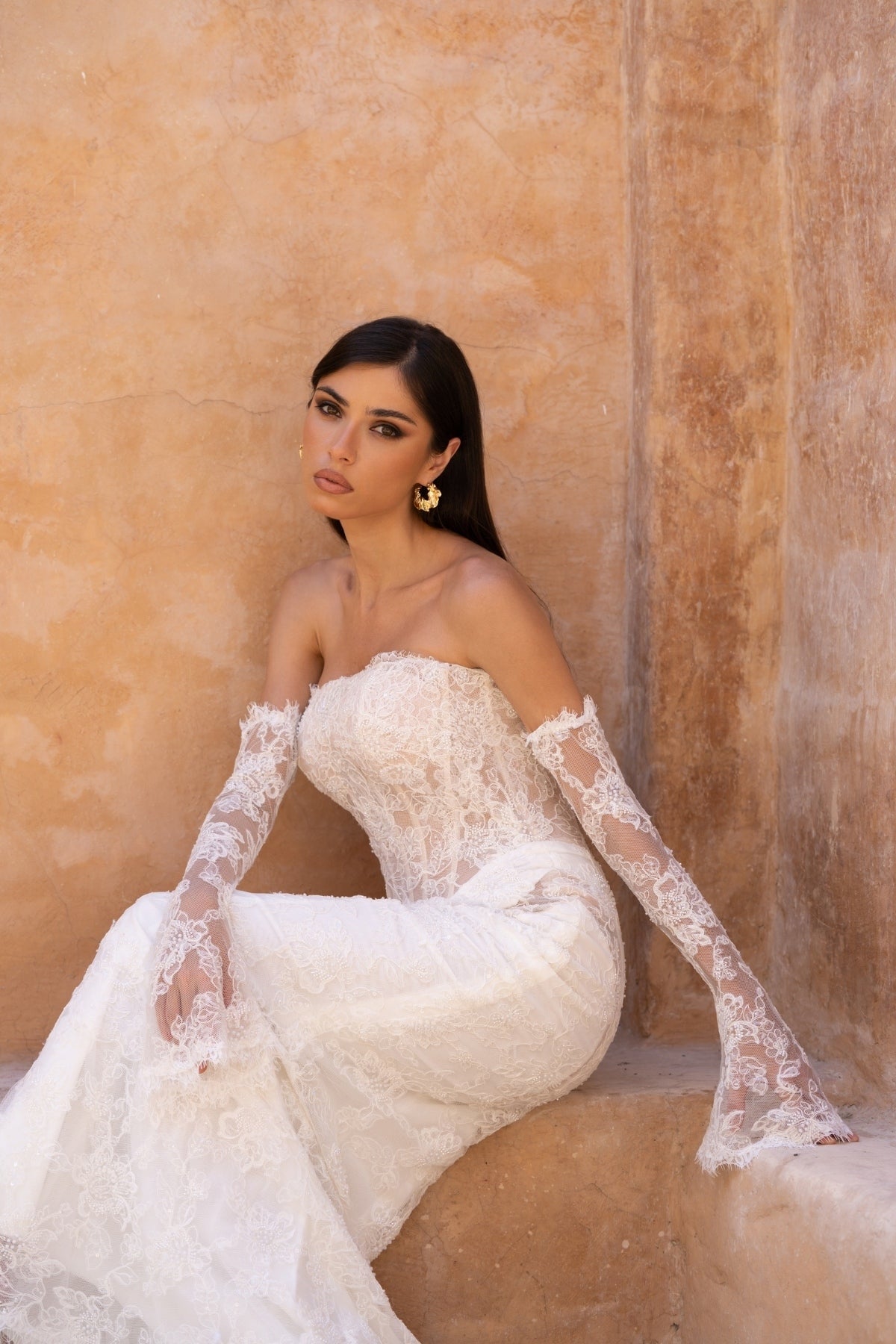 fitted lace wedding dress with basque waist, cat-eye neckline and side cut-outs. paired with fitted lace sleeves. 