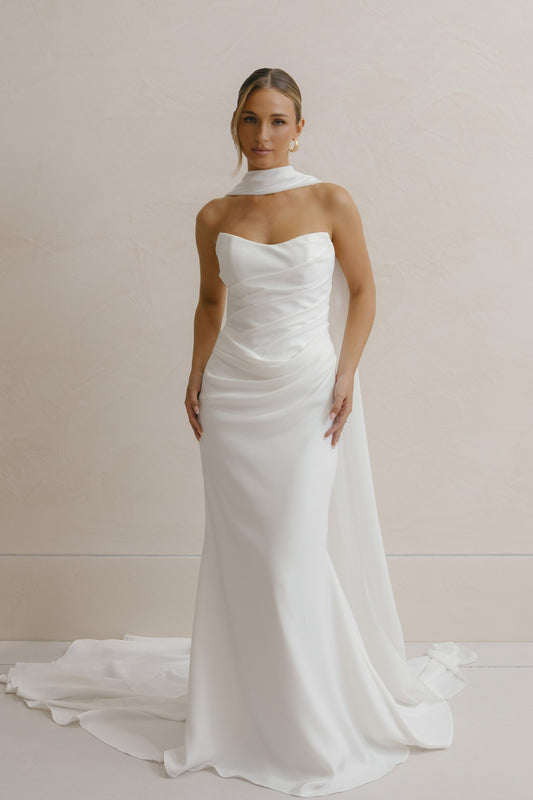 fitted crepe Bridal gown, strapless neckline, drapings around bust and hips. Paired with a scarf 
