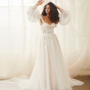 Model wears soft tulle Sky gown with detachable Sky Sleeves, a soft tulle balloon sleeve with floral applique cuffs.