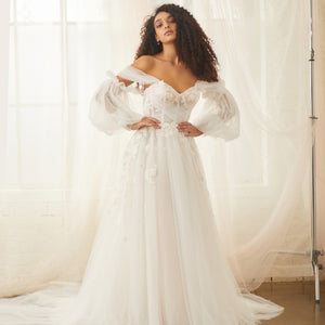 Model wears Sky Gown with detachable Sky Sleeves made from billowing tulle that cinches in the middle of the upper arm. 