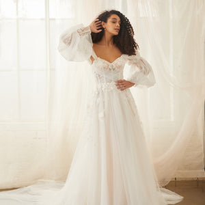 Model wears sky wedding dress with detachable balloon sleeves made from soft tulle with floral applique cuffs