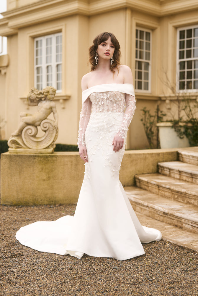 Model wears Theia wedding dress with detachable fitted sleeves. Lace matches the gown.