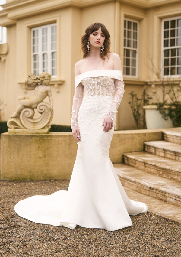 Model wears Theia wedding dress with detachable fitted sleeves. Lace matches the gown.