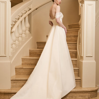 Back view of model wearing tamsin overskirt. A detachable overskirt with structured lining.